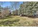 Expansive backyard with mature trees, lush lawn, and a wooden deck at 286 Warwick Pl, Castle Pines, CO 80108