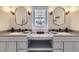 Modern bathroom featuring dual vanities, framed mirrors, and under-cabinet storage at 286 Warwick Pl, Castle Pines, CO 80108