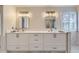 Bathroom with dual sinks, modern lighting fixtures, and a large framed mirror at 286 Warwick Pl, Castle Pines, CO 80108