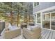 Spacious outdoor deck with comfortable seating surrounded by mature trees at 286 Warwick Pl, Castle Pines, CO 80108