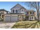 Charming two-story home with brick and siding, featuring a three-car garage and well-maintained front yard at 286 Warwick Pl, Castle Pines, CO 80108