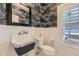 This updated half bath features black-and-white patterned wallpaper and a sleek sink at 286 Warwick Pl, Castle Pines, CO 80108
