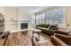 Cozy living room with a fireplace, hardwood floors, bright windows, and modern furniture at 286 Warwick Pl, Castle Pines, CO 80108