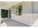 Covered patio with stone pillars, string lights, and artificial hedge at 5601 E Iowa Ave, Denver, CO 80224