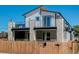 Modern two-story home with white and gray exterior, stone accents, and balcony at 5601 E Iowa Ave, Denver, CO 80224