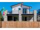 Modern two-story home with white and gray exterior, stone accents, and a balcony at 5601 E Iowa Ave, Denver, CO 80224