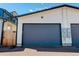 Attached two-car garage with gray doors and white exterior at 5601 E Iowa Ave, Denver, CO 80224