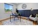 Home office with a desk, chair, and dark blue accent wall at 5601 E Iowa Ave, Denver, CO 80224