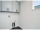 Basement laundry room with gray cabinets and window at 5601 E Iowa Ave, Denver, CO 80224