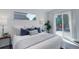 Main bedroom with a comfortable bed and access to a deck at 5601 E Iowa Ave, Denver, CO 80224