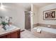 Bathroom with double sinks, glass shower, and soaking tub accented by neutral tile and decorative art at 505 S Main St # 1313, Breckenridge, CO 80424