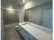 Well lit bathroom featuring double vanity, shower and tub combo, and light tile at 17719 Prairie Peak Trl, Parker, CO 80134