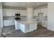 Spacious kitchen features white cabinets, stainless steel appliances, and a large center island with quartz countertop at 17719 Prairie Peak Trl, Parker, CO 80134