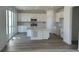 Bright kitchen with white cabinets, stainless steel appliances, a center island with a quartz countertop, and sliding glass doors at 17719 Prairie Peak Trl, Parker, CO 80134