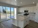 Bright kitchen with white cabinets, stainless steel appliances, a center island with a quartz countertop, and sliding glass doors at 17719 Prairie Peak Trl, Parker, CO 80134