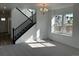 Inviting living room with large windows, staircase, and a chandelier at 17719 Prairie Peak Trl, Parker, CO 80134