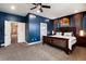 Spacious bedroom featuring a ceiling fan and a cozy layout with neutral carpet and blue walls at 2334 Lowell Blvd, Denver, CO 80211