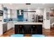 Kitchen featuring stainless steel appliances, an island with seating, and bright blue tile backsplash at 2334 Lowell Blvd, Denver, CO 80211