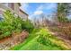 Well-maintained backyard with green lawn, garden shrubs, and wood fence at 18142 E Oakwood Pl, Aurora, CO 80016