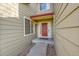 Inviting front entry featuring a red front door, sidelight windows, and rock landscaping at 18142 E Oakwood Pl, Aurora, CO 80016