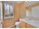 Cozy half bathroom featuring patterned wallpaper, white vanity, and natural light from window at 18142 E Oakwood Pl, Aurora, CO 80016