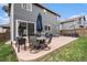 Backyard patio featuring an outdoor dining set, a patio umbrella, a grassy area and a basketball hoop at 9250 Roadrunner Dr, Highlands Ranch, CO 80129