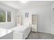 A serene bedroom with white furniture, including a bed, shelves, and a window offering natural light and a view at 9250 Roadrunner Dr, Highlands Ranch, CO 80129
