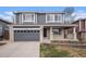 Charming two-story home with a gray exterior, brick accents, landscaped front yard, and attached two-car garage at 9250 Roadrunner Dr, Highlands Ranch, CO 80129