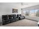 Spacious living room featuring dual recliners, large windows offering neighborhood views, and a ceiling fan at 9250 Roadrunner Dr, Highlands Ranch, CO 80129