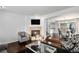A modern living room is open to the dining area, has hardwood floors, and a fireplace at 9250 Roadrunner Dr, Highlands Ranch, CO 80129