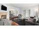 A modern living room is open to the dining area, has hardwood floors, a fireplace, and stylish decor at 9250 Roadrunner Dr, Highlands Ranch, CO 80129