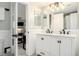 Bathroom with dual sink vanity, updated fixtures, and an open doorway to the adjacent living space at 972 S Zeno Way, Aurora, CO 80017