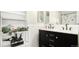 Well-lit bathroom with a double vanity, marble countertop, modern fixtures, and decorative shelving at 972 S Zeno Way, Aurora, CO 80017