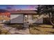 Charming single-story home at dusk featuring walkway and mature tree under a vibrant sky at 972 S Zeno Way, Aurora, CO 80017