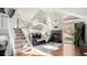 Bright living room featuring vaulted ceilings, a stone fireplace, and open staircase at 972 S Zeno Way, Aurora, CO 80017
