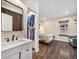 Bedroom featuring wood flooring and a connecting bathroom with a white vanity and sink at 1247 S Idalia St, Aurora, CO 80017