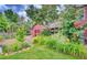 Landscaped backyard featuring lush greenery, a red shed, a playhouse, and a pergola with outdoor seating at 124 E Colorado Ave # 2, Denver, CO 80210