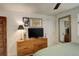 Comfortable bedroom with a wooden dresser, a modern television, and a full-length mirror at 124 E Colorado Ave # 2, Denver, CO 80210