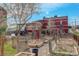 Backyard garden with raised beds, a red brick house, and a wooden pergola on a sunny day at 124 E Colorado Ave # 2, Denver, CO 80210