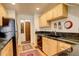 Compact kitchen features wood cabinets, black countertops, and stainless steel appliances at 124 E Colorado Ave # 2, Denver, CO 80210