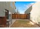 Fenced backyard with a small patio, outdoor dining set, and view of the modern home's architecture at 4544 Utica St, Denver, CO 80212