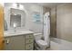 Cozy bathroom features a shower-tub combo with stylish curtain and a vanity with storage at 4544 Utica St, Denver, CO 80212