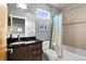 Modern bathroom featuring sleek black vanity, neutral tile, and shower with decorative curtain at 4544 Utica St, Denver, CO 80212