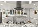 Bright kitchen showcasing white cabinets, granite countertops, stainless steel appliances, and a modern range hood at 4544 Utica St, Denver, CO 80212