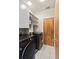 Laundry room features modern washer and dryer set and ample storage shelves for convenience at 4544 Utica St, Denver, CO 80212