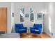 Bright living room with hardwood floors, blue armchairs, large windows, and stylish decor create a welcoming ambiance at 4544 Utica St, Denver, CO 80212