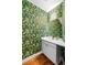 Stylish powder room featuring vibrant wallpaper, modern fixtures, and wood floors at 4544 Utica St, Denver, CO 80212