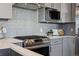 Modern kitchen featuring gray cabinets, stainless steel range hood, and new appliances at 1259 Perry St, Denver, CO 80204