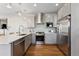 Kitchen featuring stainless steel appliances, gray cabinets, quartz countertops, and modern fixtures at 1259 Perry St, Denver, CO 80204