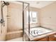 Bright bathroom featuring an updated tile shower, soaker tub, updated fixtures, and a neutral color palette at 7506 Sabino Ln, Castle Rock, CO 80108